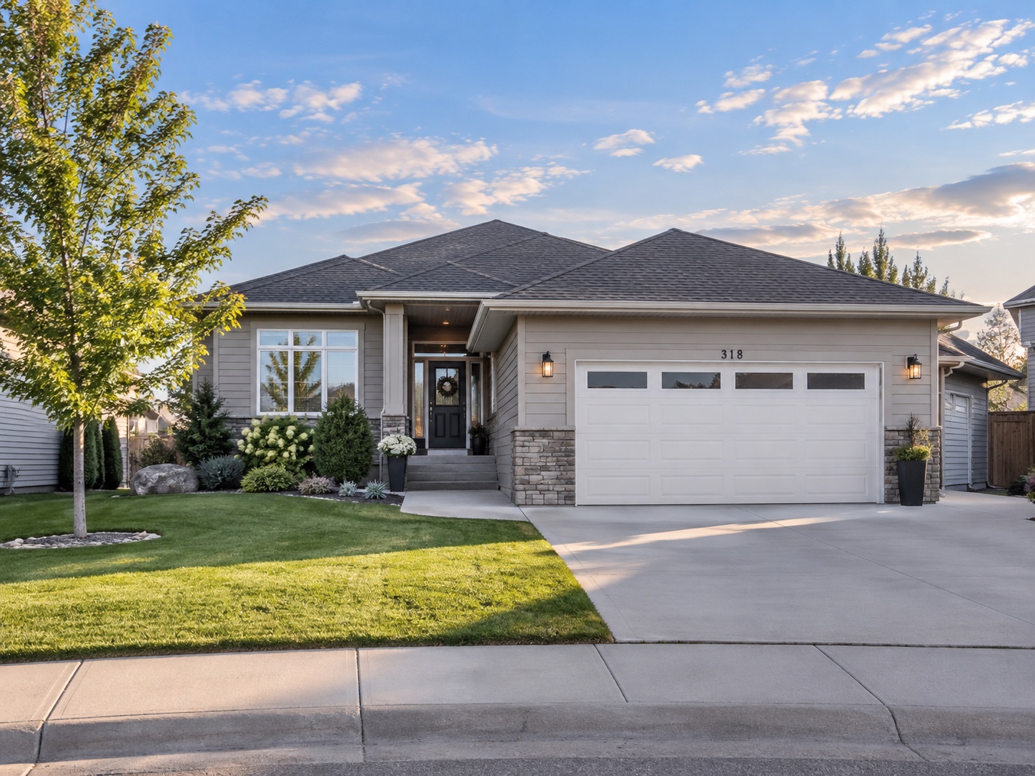 An illustrative Saskatchewan suburban home with a front garage and landscaped lawn; not a property listing